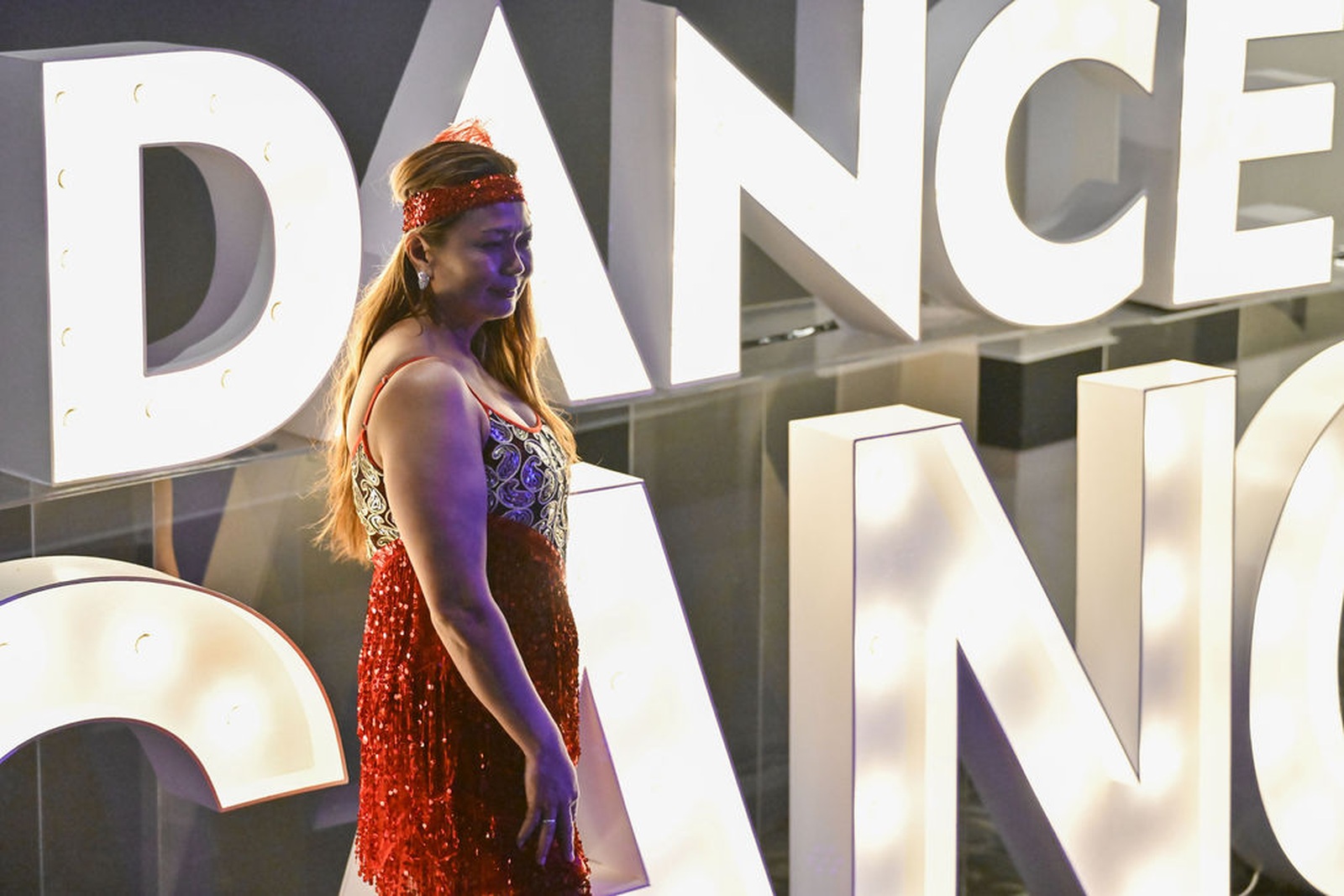 Dance for Cancer participant performing in front of the illuminated stage